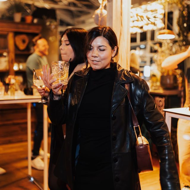 Guests with drinks in a warmly lit venue during a Christmas party