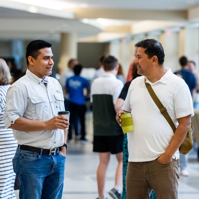 Two delegates talking over coffee during the break at a conference
