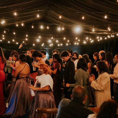 A packed wedding dance floor beneath hundreds of hanging fairy lights