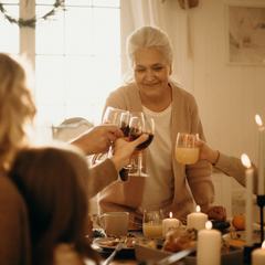 A family raising glasses across a candlelit dinner table at home
