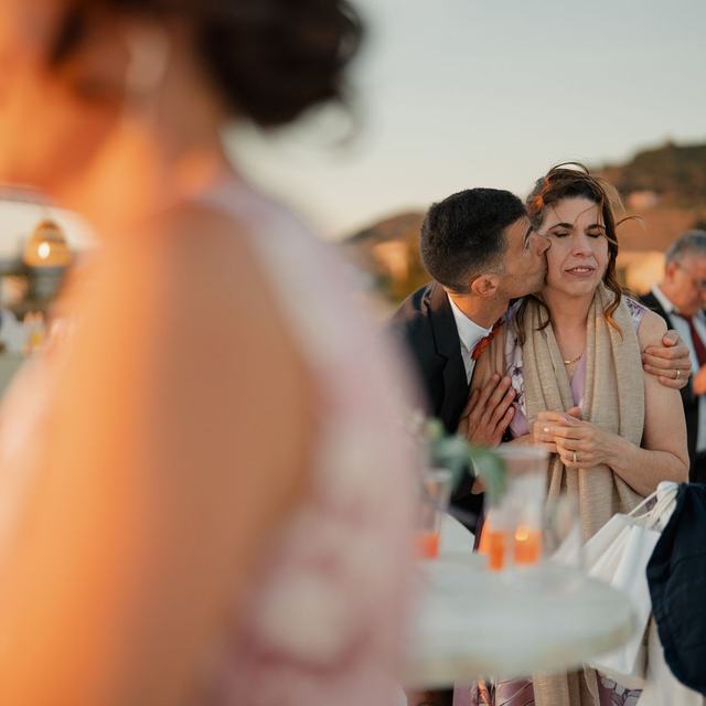 An out-of-focus snapshot of guests mingling with drinks at a sunset reception