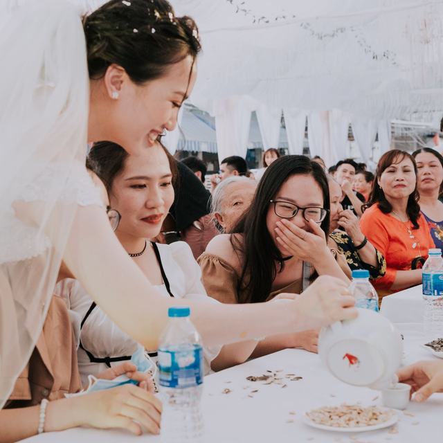 A washed-out snapshot of wedding guests seated along a crowded banquet table